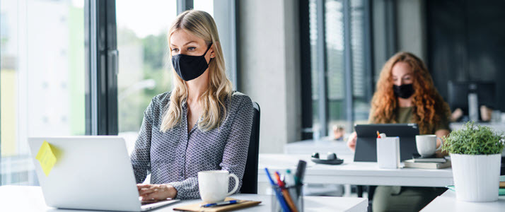women coworkers at their desks wearing face masks women coworkers at their desks wearing face masks