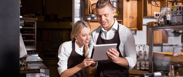 Cafe workers using computer tablet