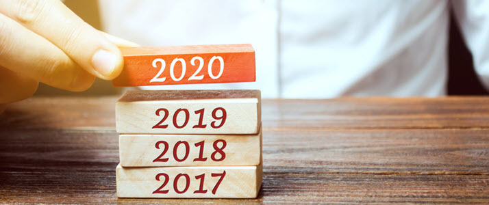 businessman builds stack of blocks with 2020 on top businessman builds stack of blocks with 2020 on top