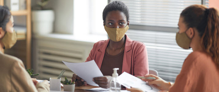 A smiling employee unpacks items at their desk