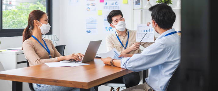 Three coworkers discuss data in conference room