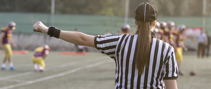 A female American football referee giving signal