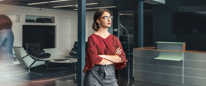 Young business woman in conference room looking ahead thinking