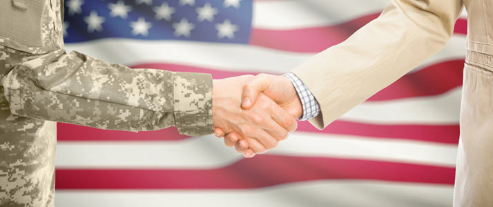 A veteran and businessman shaking hands with US flag in background