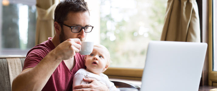man with laptop and baby in cafe working