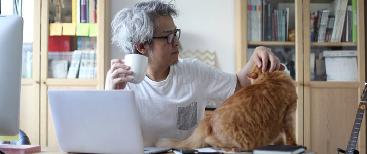 An employee works from his desk at home