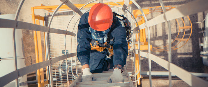 male worker in hard hat climbing ladder outside Why You Should Require Liability Insurance from your Contractors