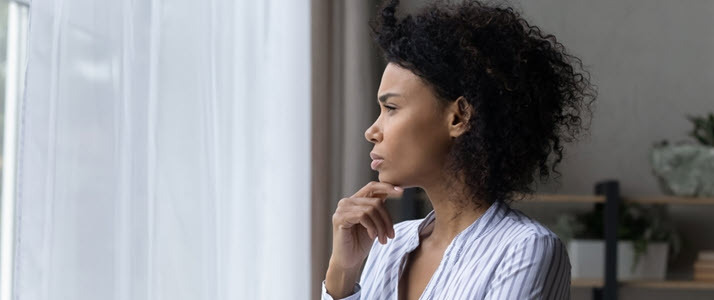 Black business woman at window considering future of her payroll team