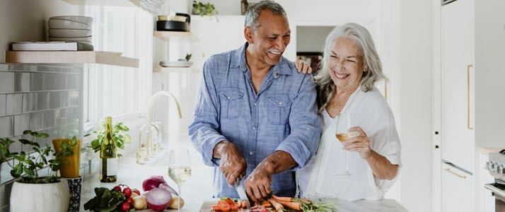 retired couple cooking together in kitchen
