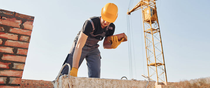 construction worker laying brick at job site construction worker laying brick at job site