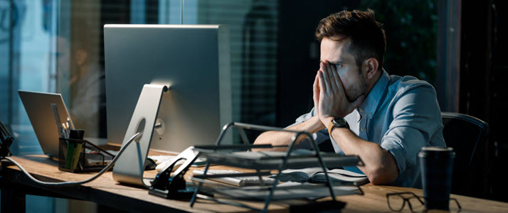Man staring at computer screen frustrated with HR software