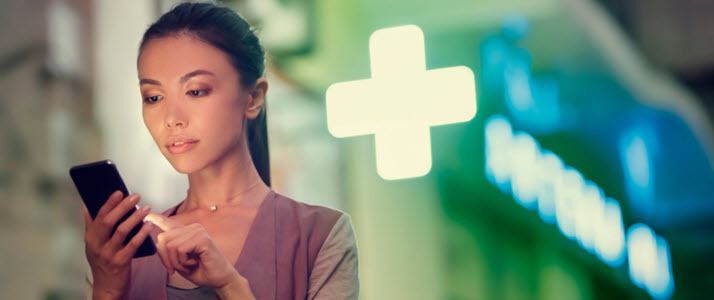 young Asian woman looking at smartphone standing outside ER young Asian woman looking at smartphone standing outside ER