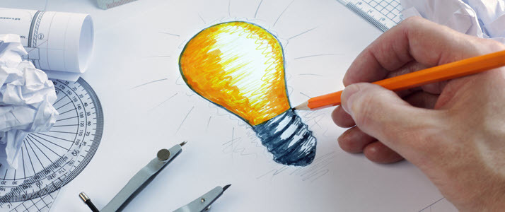 hand of designer drawing a light bulb illustrating innovation