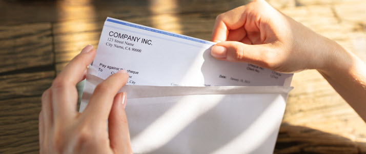 business person opening envelope with final pay check business person opening envelope with final pay check