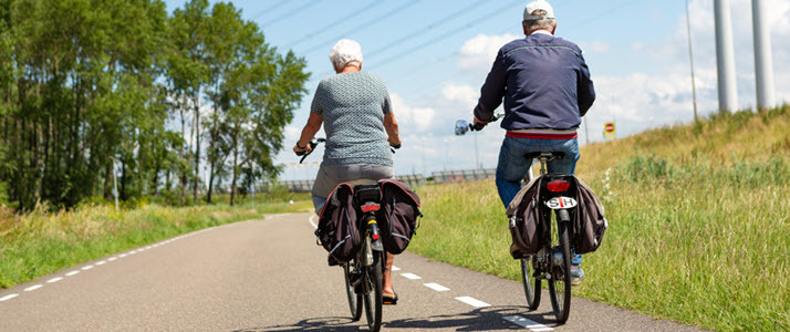 active couple enjoying retirement riding bicycles with child