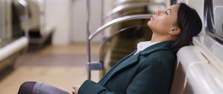 exhausted young businesswoman resting on subway train