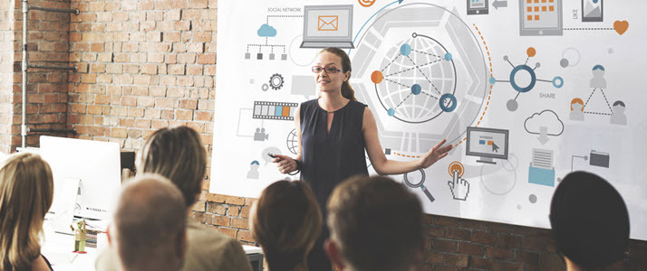 Woman leading meeting with payroll function diagram on whiteboard