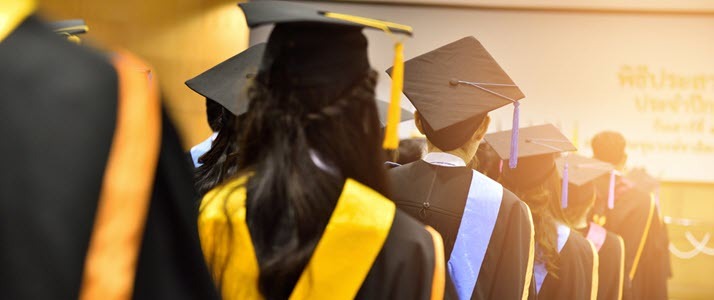 photo showing backs of graduates lined up for ceremony