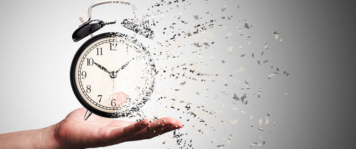 Retro alarm clock in hand fragmenting disappearing Retro alarm clock in hand fragmenting disappearing