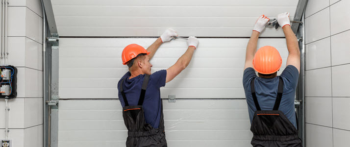 two workers installing garage door