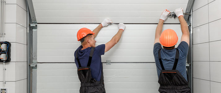 two workers installing garage door two workers installing garage door