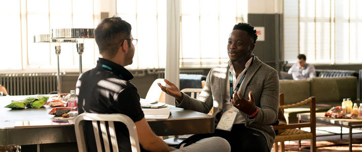 Sponsorship vs Mentorship Which Model Is Best Two colleagues sit facing one another having a conversation in an office