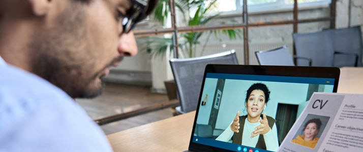An interviewer reviews an interviewees credentials while meeting virtually