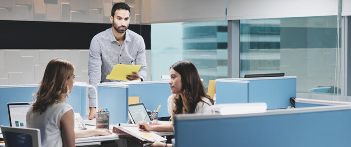 Which One Doesnt Belong How to Foster Belonging in the Workplace standing man being ignored by female coworkers at nearby desk