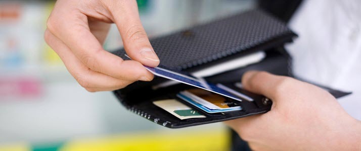 hands of person pulling pay card out of wallet