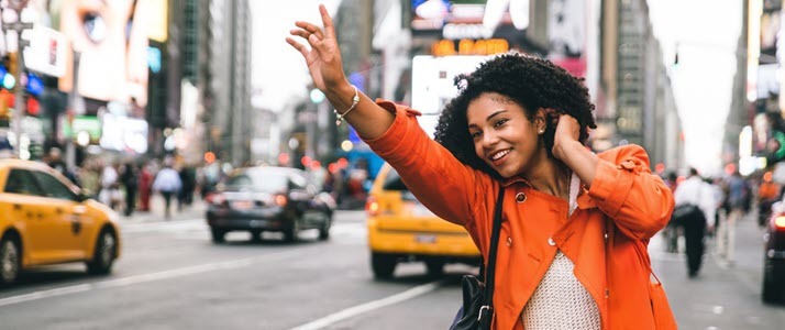 woman in Times Square hailing taxi on busy street woman in Times Square hailing taxi on busy street