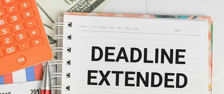 Image of deadline extended written on desk notebook