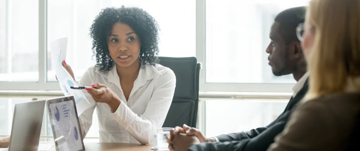 A side view of two clients with accountant reviewing pie chart