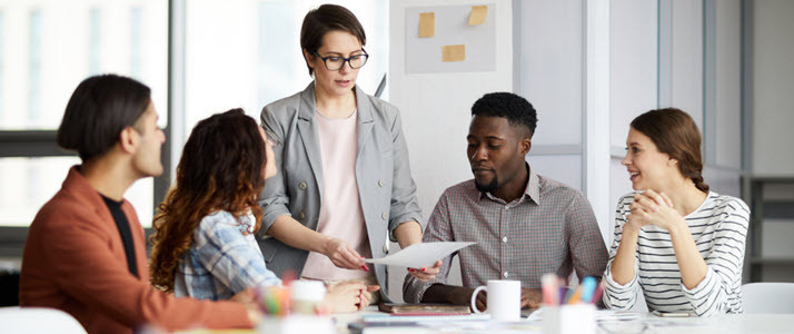 What Is Business Agility and Why Does It Matter A group of colleagues sitting around a conference table while reviewing an agile business plan