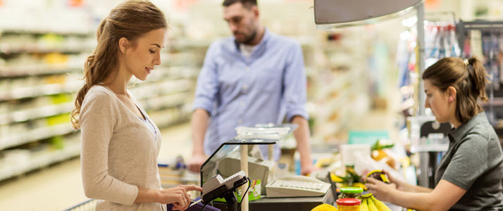 Young woman using pay card to buy groceries for family