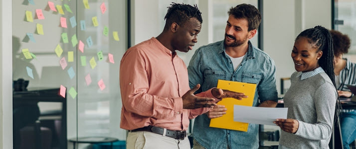 5 Tips for Efficient Internal Communications three colleagues communicate in an office workspace