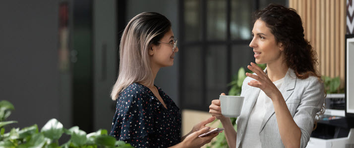 The Great Reengagement Retention Strategies That Actually Work Two women talk together while at work in an office