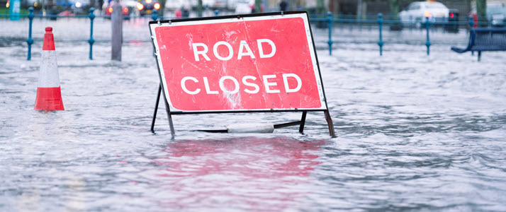 photo of a road closed sign on flooded road