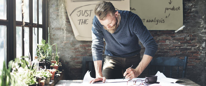 man standing hurridly filling in timesheet before deadline man standing hurridly filling in timesheet before deadline