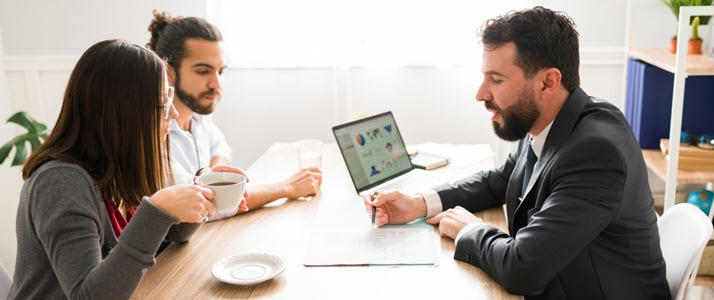 Financial advisor reviewing documents with a married couple Financial advisor reviewing documents with a married couple