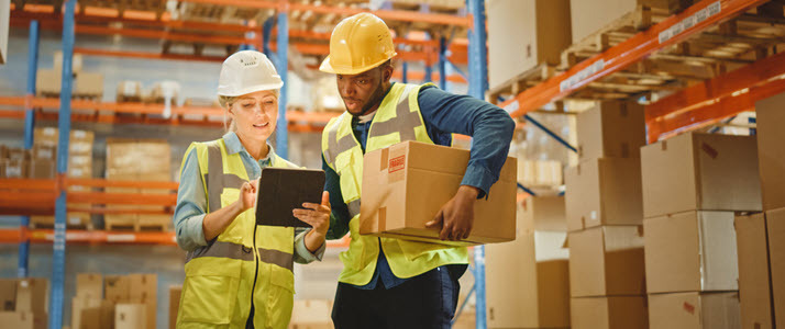 female supervisor and warehouse worker looking at digital tablet