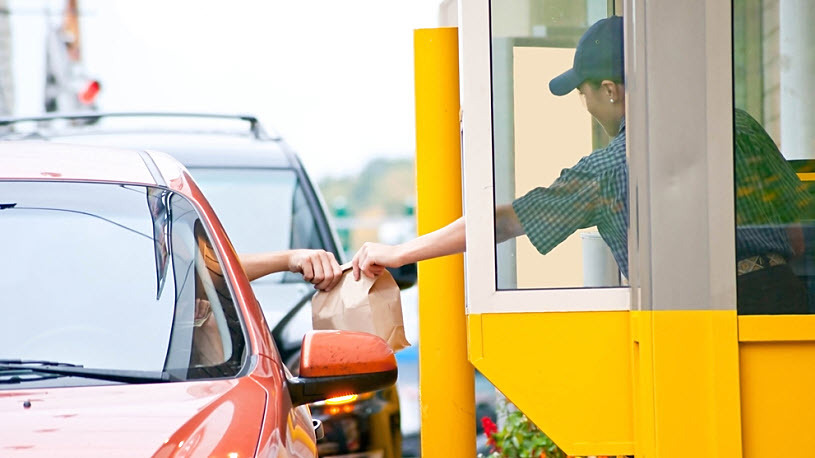 Decorative image - drive-thru fast food worker handing sack out