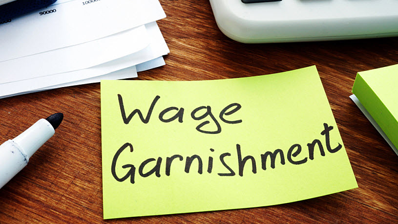 decorative image showing words wage garnishment written on note decorative image showing words wage garnishment written on note
