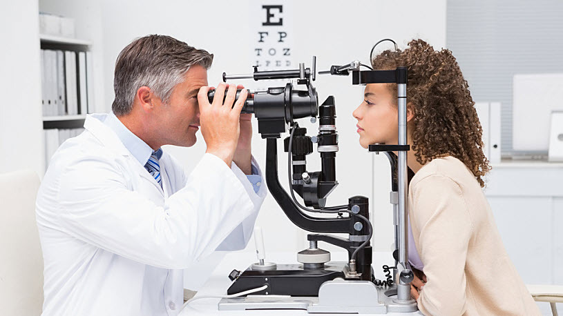 decorative image showing a woman getting an eye test at an optometrist's office