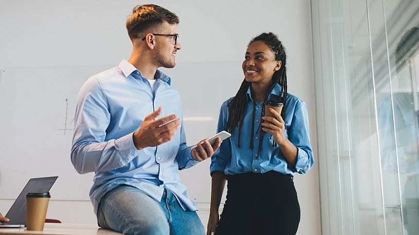 employee experience conversation Young male and female coworkers chat in conference room