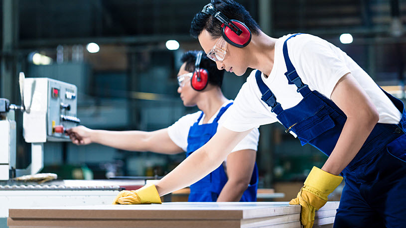 Woodworkers in carpentry cutting board on saw Woodworkers in carpentry cutting board on saw