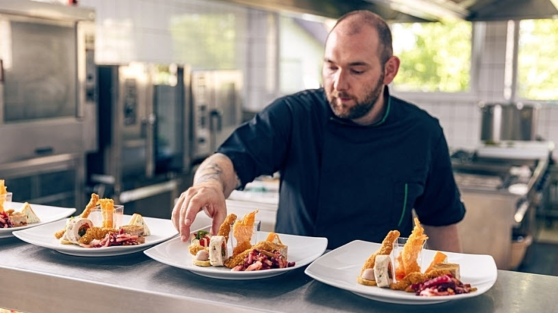 Thrive restaurants boosts employee retention cook prepares plates in the kitchen