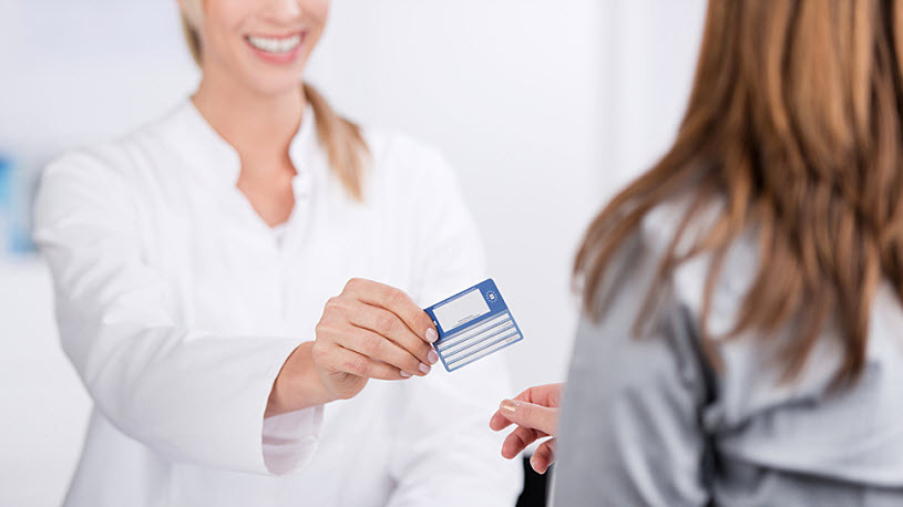 Smiling young doctor giving heatlh card to patient Smiling young doctor giving heatlh card to patient