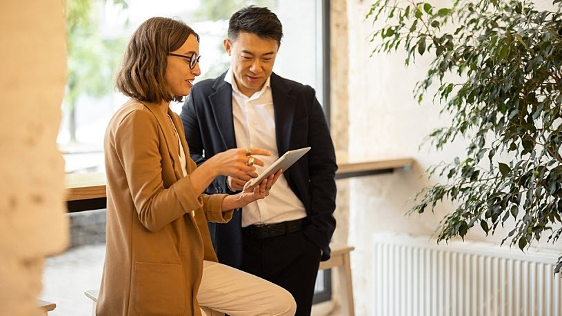 business woman showing data to male employee on tablet in office business woman showing data to male employee on tablet in office