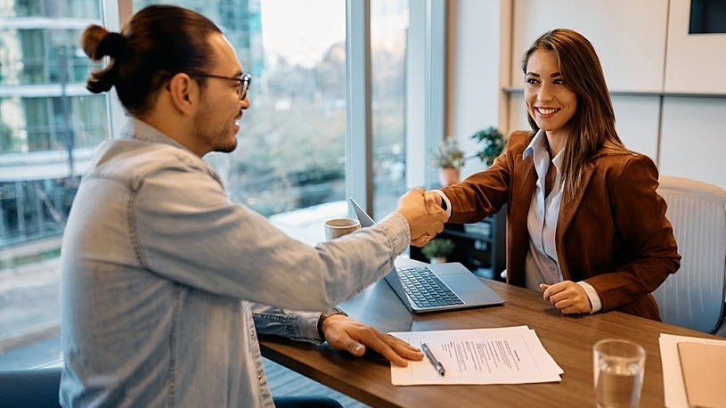 Man and woman in professional office building shake hands Man and woman in professional office building shake hands