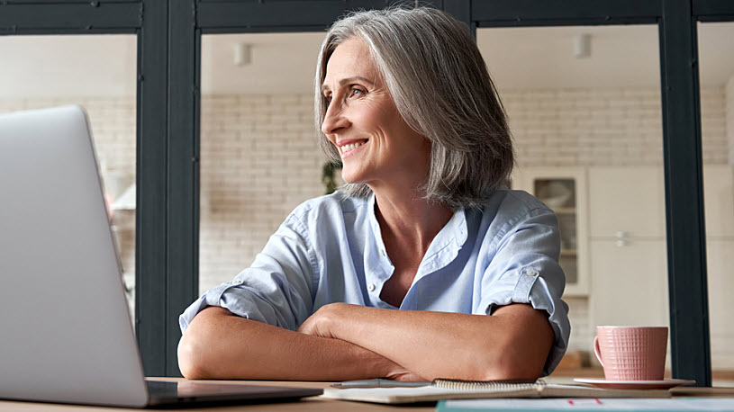 Smiling middle aged woman sitting in an office looking confident Smiling middle aged woman sitting in an office looking confident